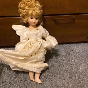 this is a glass doll with broke foot with is covered with dress